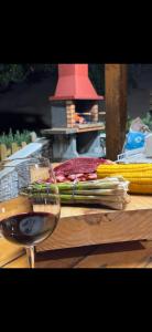 a glass of wine and some vegetables on a table at Villa balcón de azuaje in Moya +13 photos