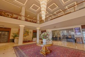 a lobby with a vase of flowers on a table at Riviera Hotel and Beach Lounge, Beirut in Beirut