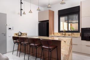a kitchen with a counter with bar stools at Katalina Luxury Apartment Eilat in Eilat