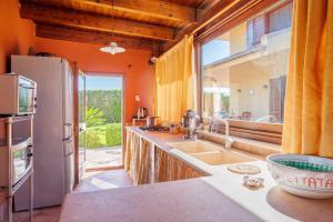 a kitchen with an orange wall and a refrigerator at Villa Tiffany in Marsala