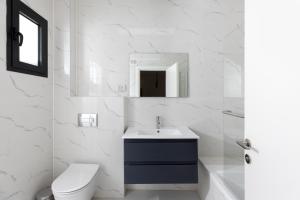 a white bathroom with a sink and a toilet at Katalina Luxury Apartment Eilat in Eilat +14 photos