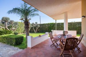 a patio with a table and chairs and a palm tree at Villa Tiffany in Marsala