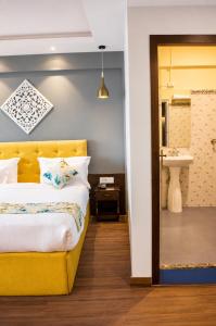 a bedroom with a yellow bed and a sink at Hotel Durga Palace in Sonepur