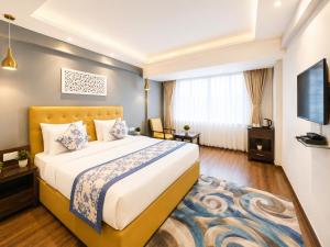 a hotel room with a bed and a television at Hotel Durga Palace in Sonepur
