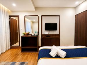 a hotel room with a bed and a mirror at Hotel Durga Palace in Sonepur