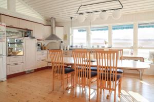 a large kitchen with a table and chairs in it at 14234-Grevinge-Strandmosen-11 in Grevinge
