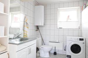 a white bathroom with a toilet and a washing machine at 14234-Grevinge-Strandmosen-11 in Grevinge +21 photos