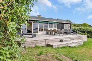 a house with a large wooden deck in the yard at 14234-Grevinge-Strandmosen-11 in Grevinge