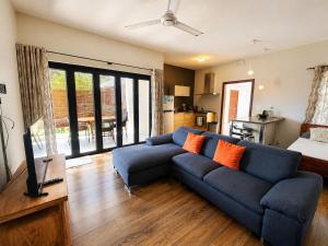 a living room with a blue couch and a television at Pingo Premium in La Gaulette