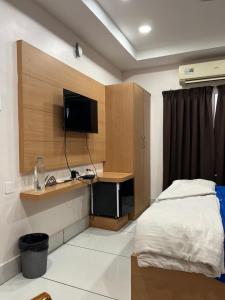 a bedroom with a bed and a desk with a television at Adhunik palace in Keonjhargarh