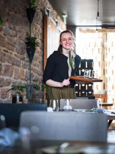 a woman standing behind a counter in a restaurant at Hotel Aux Terrasses in Tournus