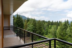 a balcony with a view of the woods at Gоderdzi Twins Hotel in Goderdzi