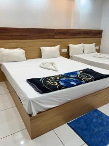 two beds in a room with white and blue carpet at Adhunik palace in Keonjhargarh