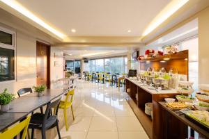 a restaurant with long tables and yellow chairs at MySpace Hotel @BGC in Manila