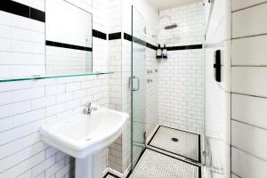 a white bathroom with a sink and a shower at Darlo Bar Darlinghurst in Sydney