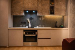 a kitchen with a stove and a sink at Pillowtalks Cloudnine Stays in Ghaziabad