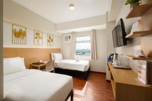 a hotel room with two beds and a television at MySpace Hotel @BGC in Manila +60 photos