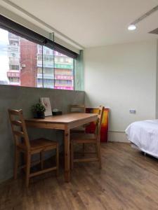 a room with a table and two chairs and a bed at Meworld Hotel - Daan in Taipei