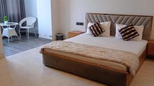 a bedroom with a large bed and a table at Hotel nsb square in Dehradun
