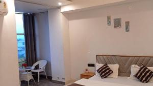 a bedroom with a bed and a table and a window at Hotel nsb square in Dehradun