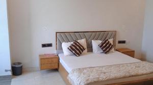 a bedroom with a bed with two pillows on it at Hotel nsb square in Dehradun