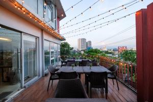 a restaurant balcony with tables and chairs and lights at MySpace Hotel @BGC in Manila