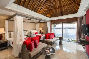 a bedroom with two beds with red pillows at Kamandalu Ubud in Ubud