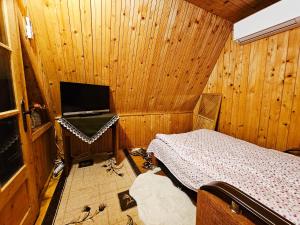 a bedroom with a bed in a wooden room at Căsuța Elena Refugiu în Natură in Buceş