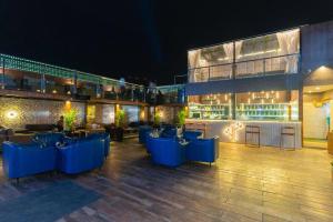 ein Restaurant mit blauen Tischen und einer Bar bei Nacht in der Unterkunft Dazzling A Boutique Hotel in Agra