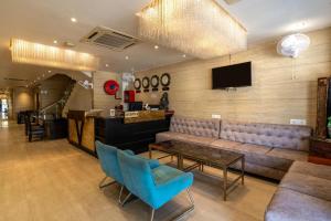 Eine Lobby mit Sofa, Fernseher und Stühlen in der Unterkunft Dazzling A Boutique Hotel in Agra