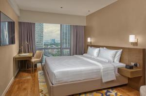 a hotel room with a bed and a large window at Novotel Suites at Acqua in Manila +63 photos