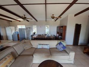 a living room with a couch and a table at Seven Sardines Beach House in Port Edward