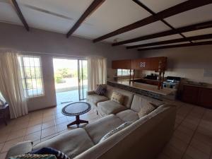 a living room with a couch and a table at Seven Sardines Beach House in Port Edward