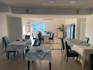 ein Restaurant mit Tischen und Stühlen und einem Speisesaal in der Unterkunft Kento Resort in Centuripe