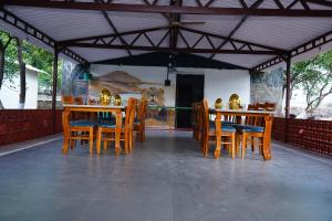 a dining room with wooden tables and chairs at Kesar Villa Resort With Swimming Pool Sasan Gir in Sāsan Gīr