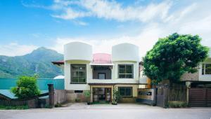 a house with a mountain in the background at Silverise Guest House in El Nido