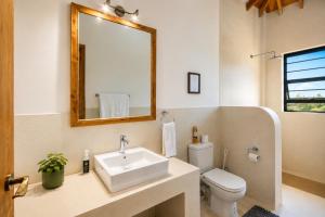 a bathroom with a sink and a toilet and a mirror at The Landing Cottages Family Suite 2 Bedroom in Nanyuki +8 photos
