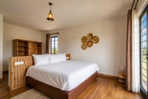 a bedroom with a bed and a large window at The Landing Cottages Family Suite 2 Bedroom in Nanyuki