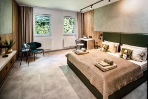 a bedroom with a large bed with two towels on it at DAS ERZ Medical Spa & Hotel in Crottendorf