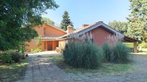 an orange house with tall grass in front of it at La Caldara House in Manziana