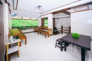 a living room with a table and benches in it at Silverise Guest House in El Nido