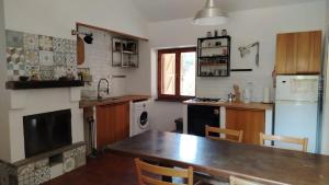 a kitchen with a wooden table and a refrigerator at La Caldara House in Manziana