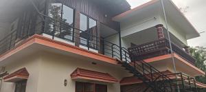 a house with a staircase on the side of it at Mount Star Home Stay in Kakkabe