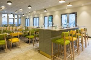a bar in a restaurant with chairs and tables at MERCURE NIMES CENTRE ARENES in Nîmes