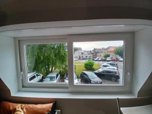 a window with cars parked in a parking lot at Studio-Cosy 17-18-19 Centre Bourbourg in Bourbourg