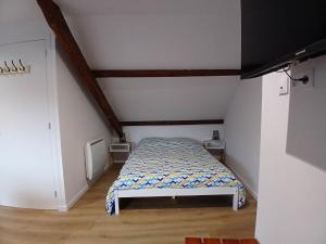 a small bedroom with a bed in a attic at Studio-Cosy 17-18-19 Centre Bourbourg in Bourbourg