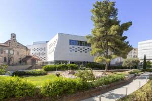 an office building with a tree in front of it at MERCURE NIMES CENTRE ARENES in Nîmes