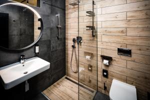 a bathroom with a sink and a shower at DAS ERZ Medical Spa & Hotel in Crottendorf