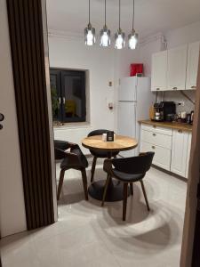 a kitchen with a table and two chairs and a table at Tudor's Rooms in Mediaş +15 photos