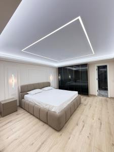 a large bed in a room with a large ceiling at Old Town Inn room 8 in Pogradec